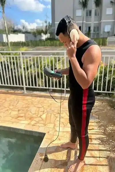 Técnico dos Serviços Caça Vazamentos detectando vazamentos em piscina com equipamento eletrônico